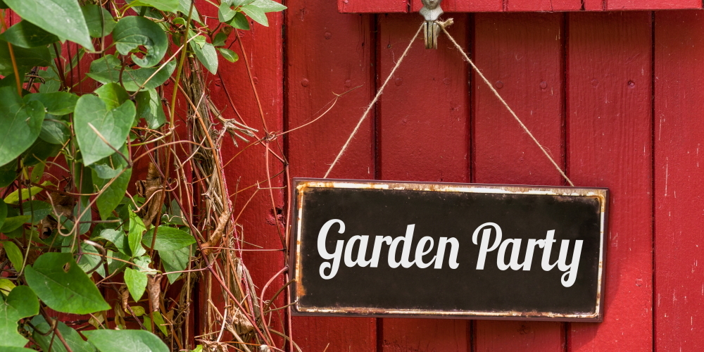 Garden party on a sign hanging from a red door